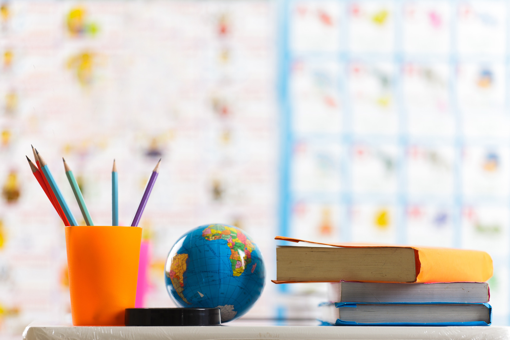 Pencils, globe and book on table